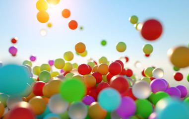Fototapeta na wymiar colorful bouncing balls outdoors against blue sunny sky