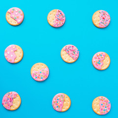 Cookies with pink glaze on blue. Food concept. Flat lay. top view.