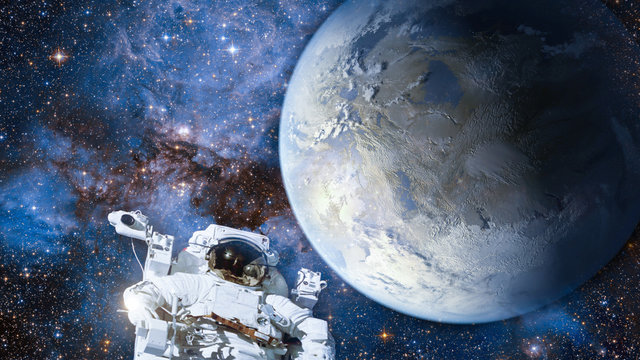 Astronaut in outer space against colorful storm galaxy and earth. (Elements of this image furnished by NASA)