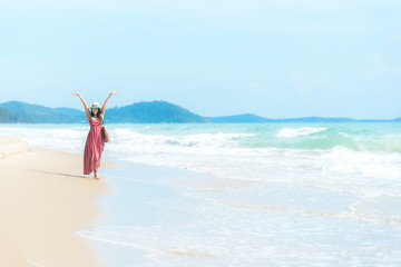 Fototapeta na wymiar Happy Holiday and Summer. Smiling asian woman wearing fashion summer walking on the sandy ocean beach. Woman enjoy and relax vacation. Lifestyle and Travel Concept