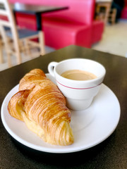 Breakfast with coffee and croissants on table