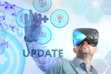 Business, Technology, Internet and network concept. Young businessman working in virtual reality glasses sees the inscription: Update