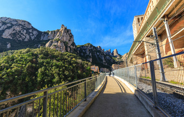 Way to the famous Catholic monastery of Montserrat on the background of round rocks. Blue sky. Catalonia, Spain - February 2017