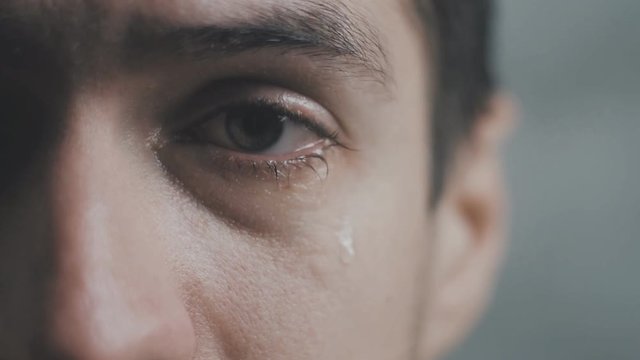 Close up of Crying man with tears in eye in slow motion