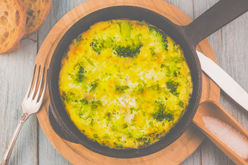 Omelette with broccoli for breakfast in a frying pan, traditional French Frittata