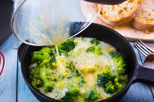 Cooking omelette with broccoli for breakfast