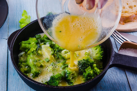 Cooking omelette with broccoli for breakfast