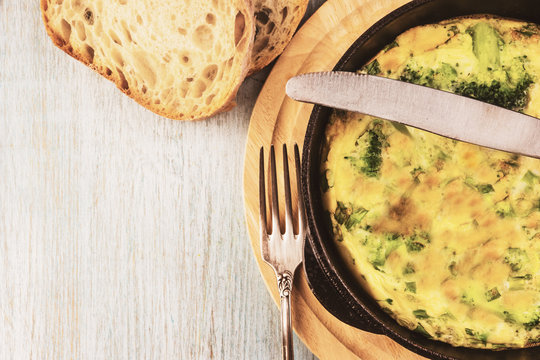 Omelette with broccoli for breakfast in a frying pan, traditional French Frittata