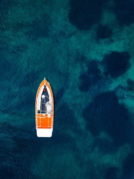 Red Boat In Deep Blue Water. Aerial View