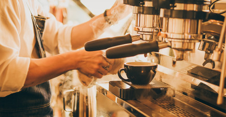 barista make coffee latte art with coffee espresso machine in coffee shop cafe in vintage color tone