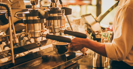 barista make coffee latte art with coffee espresso machine in coffee shop cafe in vintage color tone