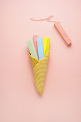 Colorful and sweet / Creative concept photo of color chalks in ice cream cone on pink background.