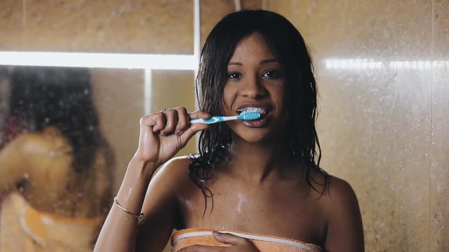 Young woman brushing teeth in bathroom