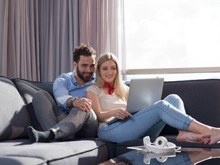 couple relaxing at  home using laptop computer