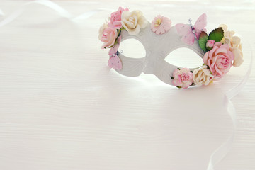 Image of delicate elegant venetian mask over wooden white background. Selective focus.