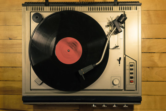 Vintage vinyl player on wooden background top view