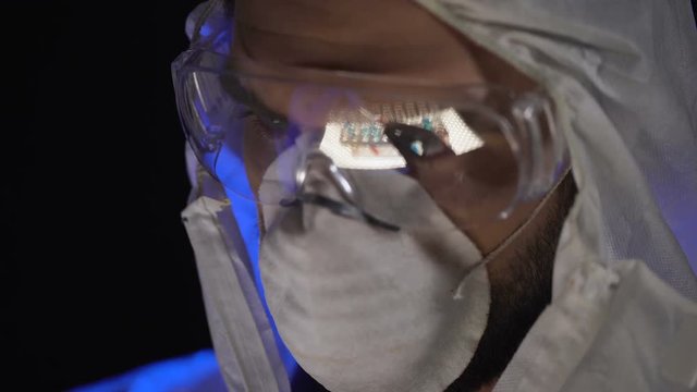 Laboratory researcher observing substance, reflection of test tubes in glasses