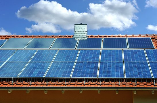 Photovoltaik- und solarthermische Anlage sowie mit Naturschiefer verschindelter Schornstein auf einem Wohngebäude