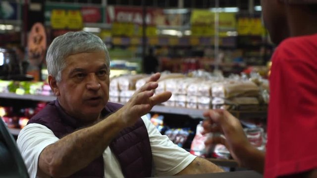 Senior Man Ordering Bread at Supermarket