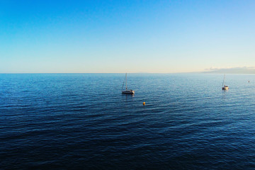 Yacht on the horizon of the spacious blue sea. With free space for text.