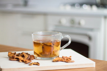 Home made delicious hot dried druit drink in a glass cup, white kitchen interior