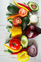 Set of fresh vegetables on a light background: tomatoes, peppers, chili, avocado, greens, onion. The concept of natural healthy eating, vegetarianism, vitamins.
