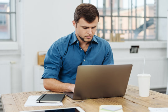 Young man working with laptop in office