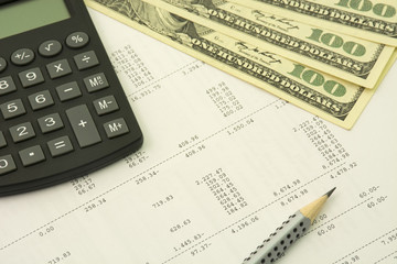 Bookkeeping concept. Dollars, pencil and calculator on a numbers background