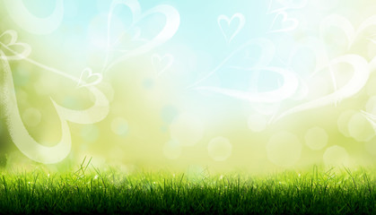 Obraz premium Blades of Green Grass with a blurred heart shape bokeh on a sky blue background.