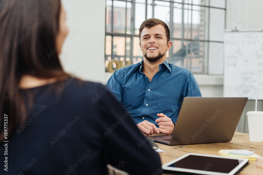 Wall mural Happy confident young man in a business meeting