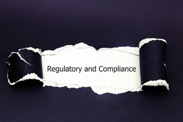 The text regulatory and compliance appearing behind torn paper
