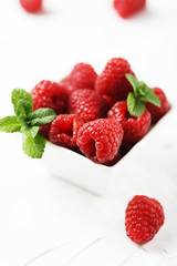Sweet fresh raspberry on the white stone background
