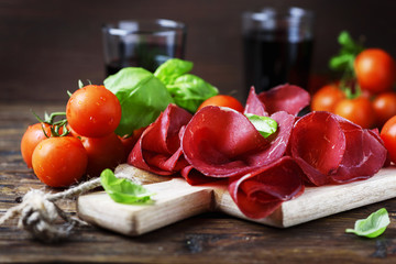 Dish of italian traditional bresaola with red wine