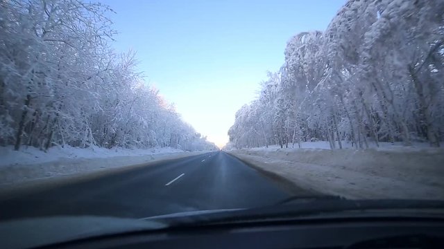 The young man slowly driving a car on a winter road. In winter, the majority of motorists still goes slow down and be careful.
