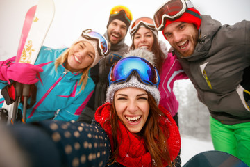 Group of friends making selfie and having fun on the snow