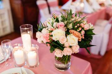 Bouquet of flowers in a vase on plate served buffet. Table setting for a wedding or dinner event, with flowers in vase of glass
