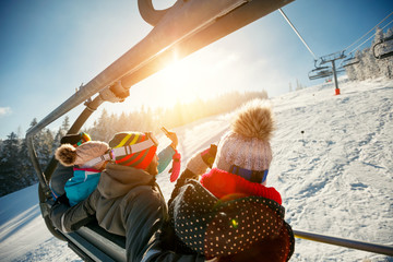 friends skiers and snowboarders on ski lift in the mountain at winter vacations - obrazy, fototapety, plakaty