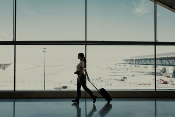 Woman at the airport walking with suitcase