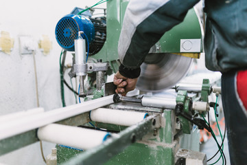 Factory for aluminum and PVC windows and doors production. Manual worker assembling PVC doors and windows. Selective focus. 