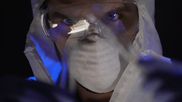 Scientist combining elements in test tube, manufacturing biological weapons