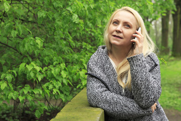 Beautiful woman in park speaks on the phone.