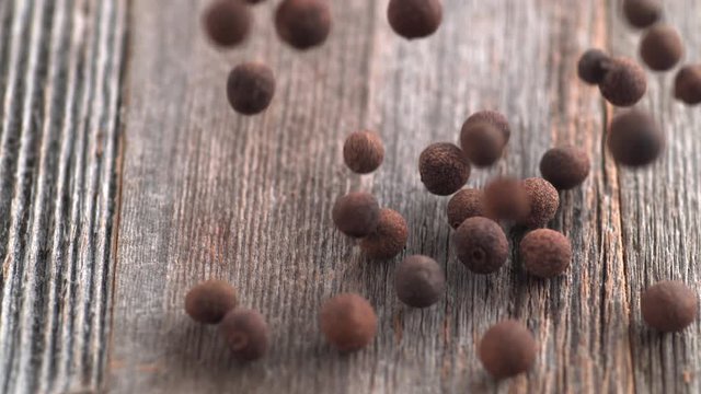 Falling allspice on wooden table. Shot with high speed camera, phantom flex 4K. Slow Motion.