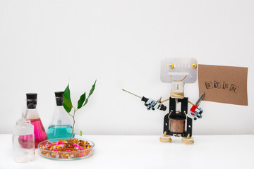 Metal robot made by hands in a class in chemistry and robotics. STEM education. Background. Free bots. Tubes, tree and microscope are on the table.