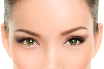 Asian beauty woman with green eyes wearing cat eye smokey eyes eyeliner makeup and mascara. Laser treatment, anti-aging eyelid plastic surgery.