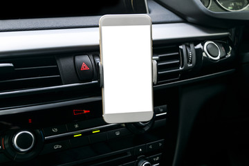Smartphone in a car use for Navigate or GPS. Driving a car with Smartphone in holder. Mobile phone with isolatede white screen. Blank empty screen. copy space. Empty space for text. 