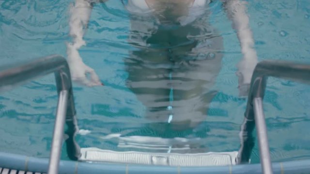 Beautiful girl coming out of the pool