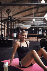 Fototapeta na wymiar Smiling young woman taking a break from her gym workout
