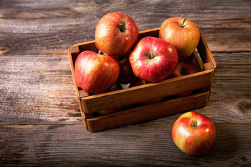 Fresh red apples in wooden box.