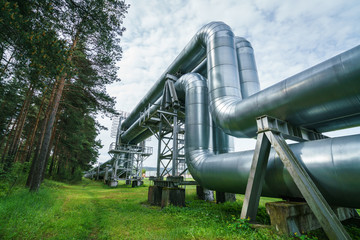 Industrial pipelines on pipe-bridge against blue sky