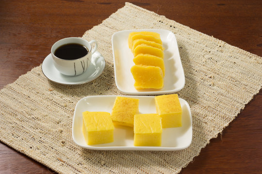 Pamonha e Canjica ou curau Brazilian Tradicional Food  made from corn with a cup of coffee(canjica ou curau  e pamonha com uma xicara de cafe no fundo madeira)